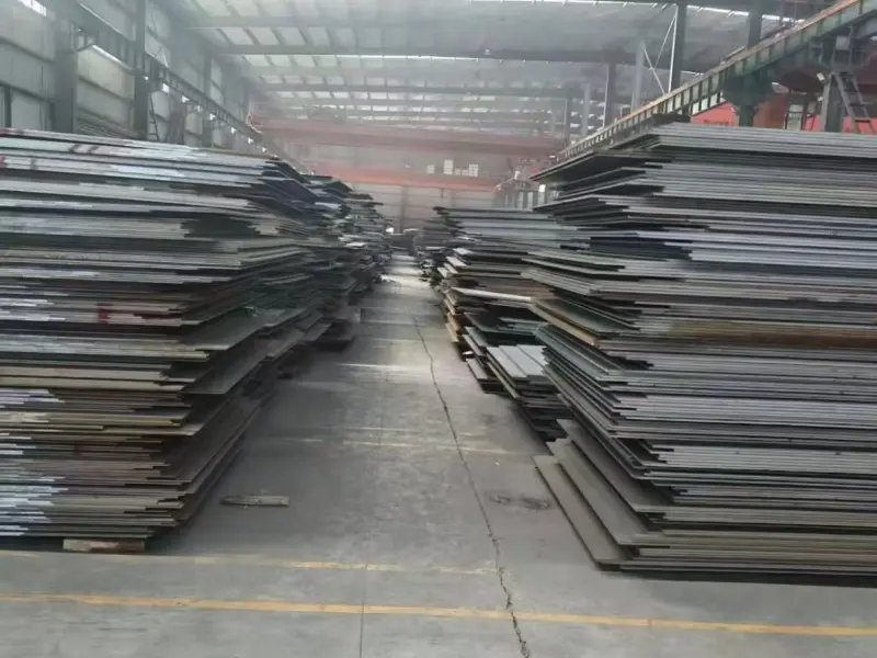 Commercial vessel under construction with steel plates stacked at the shipyard